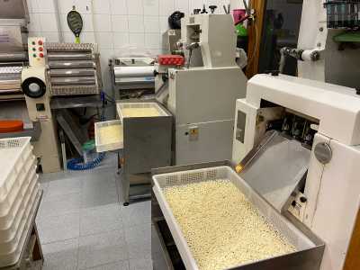 Qui notiamo le macchine per i tortellini e per i ravioli, sulle quali sono appoggiati contenitori colmi di quadrucci...
